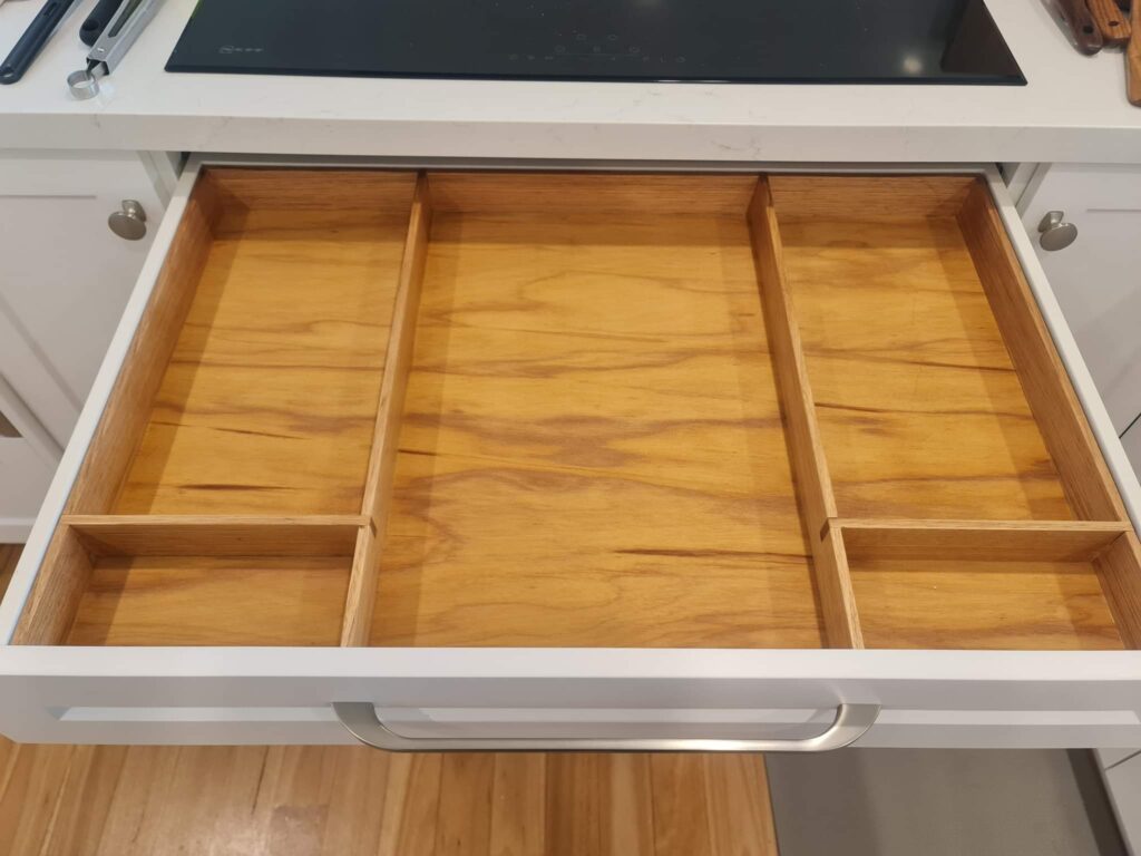 Empty cutlery and utensil drawer under induction stove top